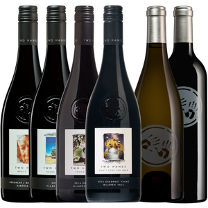Six wine bottles from Two Hands Winery arranged in a row against a white background, including dark red, black, and off-white varieties with illustrated labels and silver or white capsules.